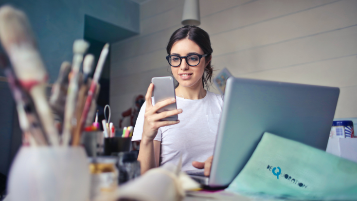 woman with computer and phone at work